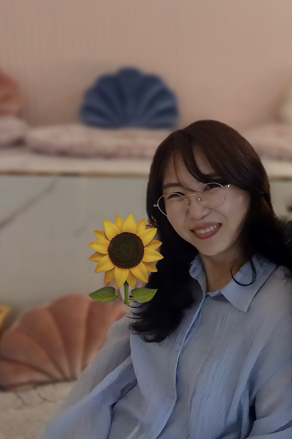 유지은 학생 중간에 꽃이 있고 활짝 웃는 모습